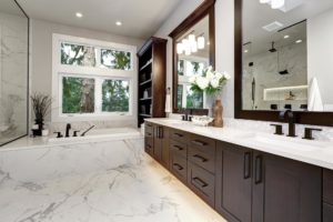 Master bathroom interior in luxury modern home with dark hardwood cabinets