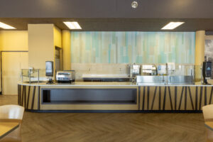 Newly-refurbished Daemen College Cafe with modern service counters, food prep stations, and self-serving areas.
