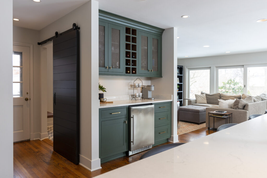 Green cabinetry, built-in minifridge, wine storage, and modern mesh cabinets.