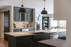 Newly renovated kitchen: two-toned white and green cabinets, an island with sink
