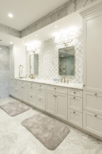 Elegantly designed bathroom with matching his and hers sinks, marble tiling, and sophisticated backsplash