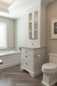 white custom cabinetry, hardwood flooring, and beige surfaces in a modern bathroom