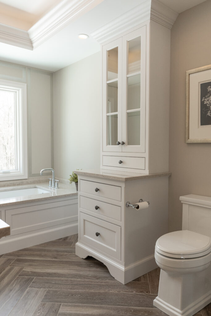 white custom cabinetry, hardwood flooring, and beige surfaces in a modern bathroom