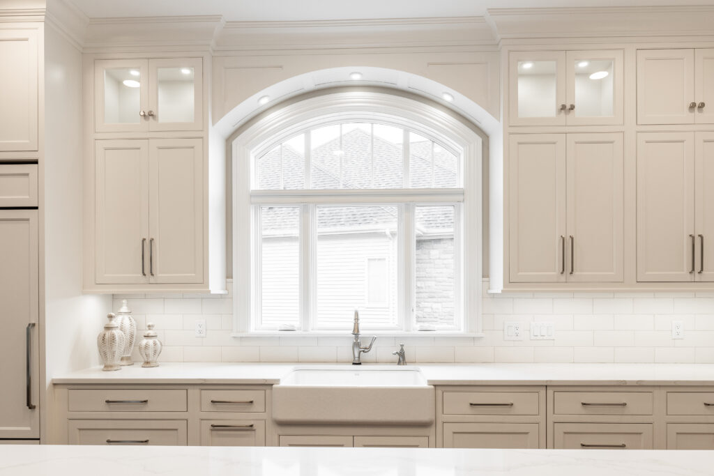 White undermount sink, countertops, and cabinetry in a renovated residential kitchen