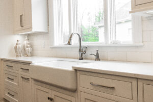 A modern white undermount sink, sleek countertops, and matching cabinetry, showcasing our 45 years of expertise in general contracting services.
