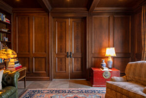 Custom dark wood-paneled double doors enhancing the luxurious aesthetic of a residential study room