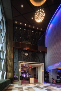 A stunning hallway view of the casino entrance at Seneca Niagara Casino. The image features the inviting bar and lounge area on the right, enriched with natural light from large windows, high ceilings, and elegant glass accents throughout the modern design.
