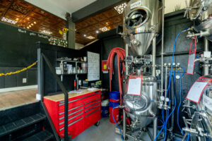 R.E. McNamara Inc.'s renovation project at One Eyed Cat Brewing features a practical workbench, metal stairs, and state-of-the-art brewing equipment.