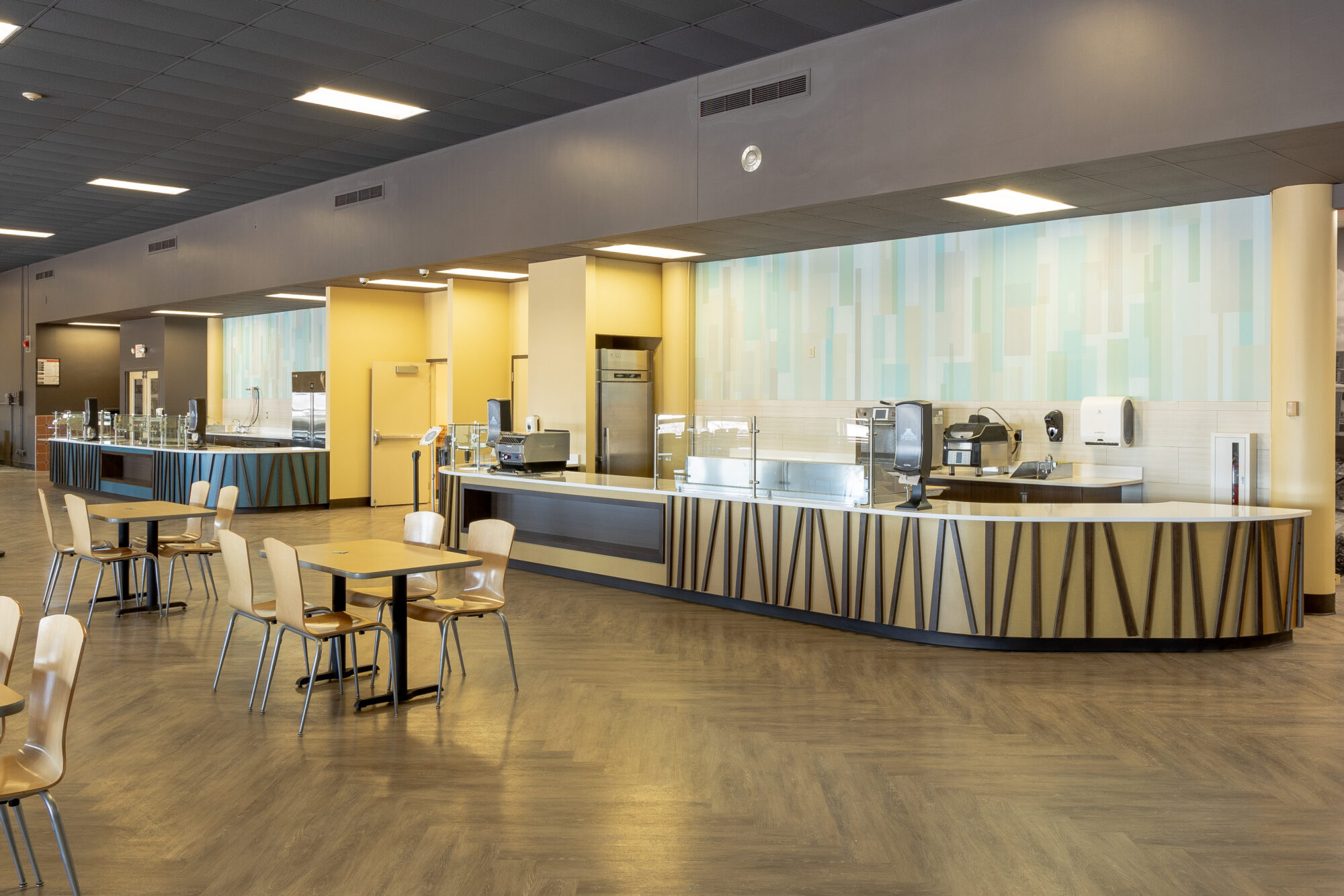 Revamped Daemen College Cafe showcasing stylish service counters with wooden accents, food preparation tables, and self-serve stations.