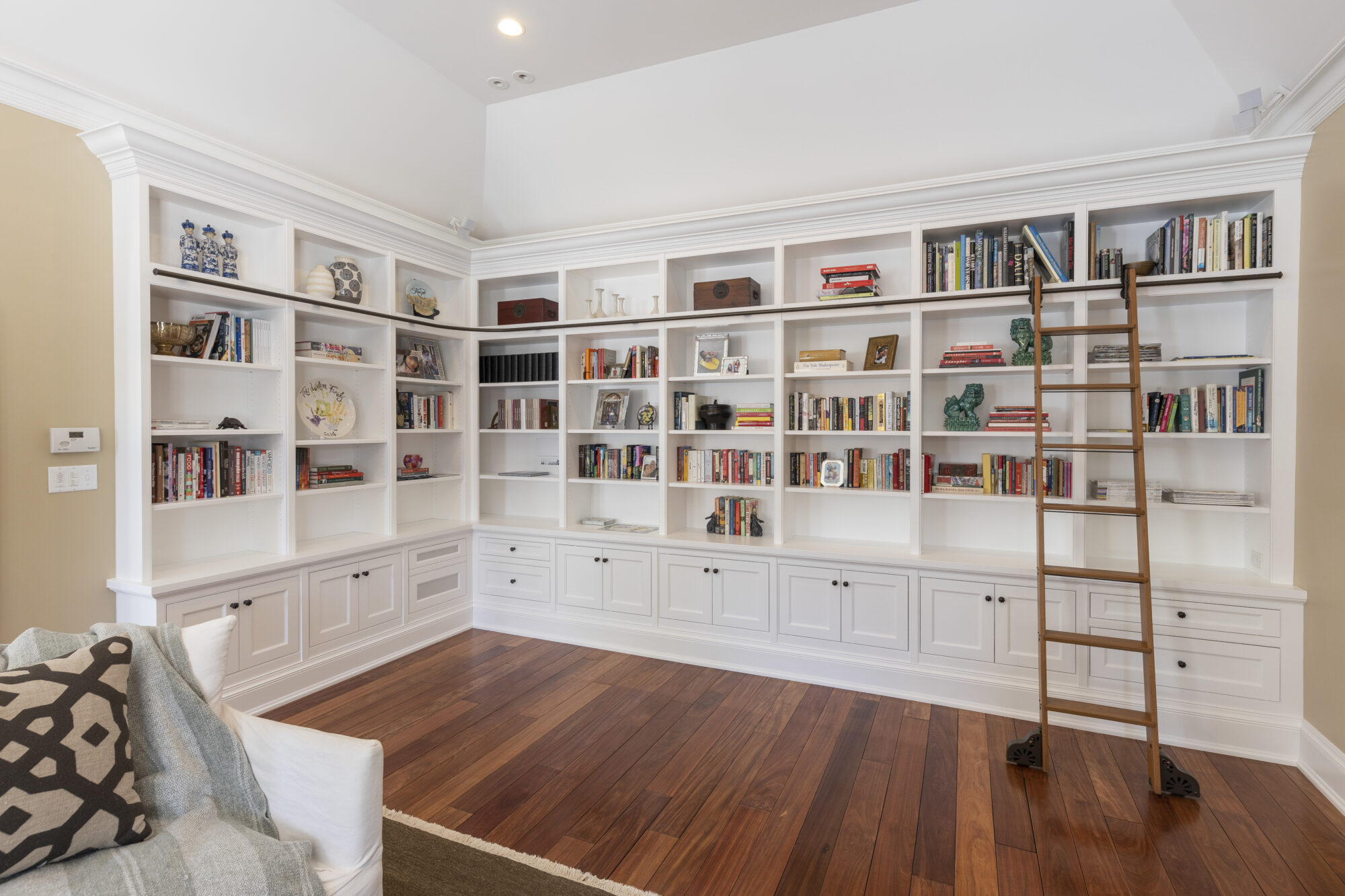Custom-built white cabinetry forms an elegant bookcase wall in a renovated residential space, reflecting R.E. McNamara Inc.'s expertise in design and craftsmanship.
