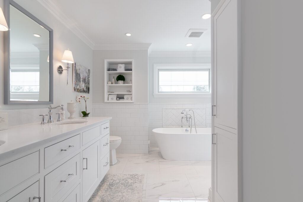 Beautifully designed white bathroom with white tiles, stylish double cabinetry, and his & hers sinks, a showcase of R.E. McNamara Inc.'s residential renovation expertise