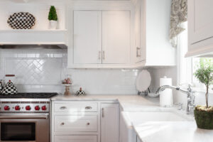 Renovated kitchen by R.E. McNamara with white cabinets and stainless steel appliances.