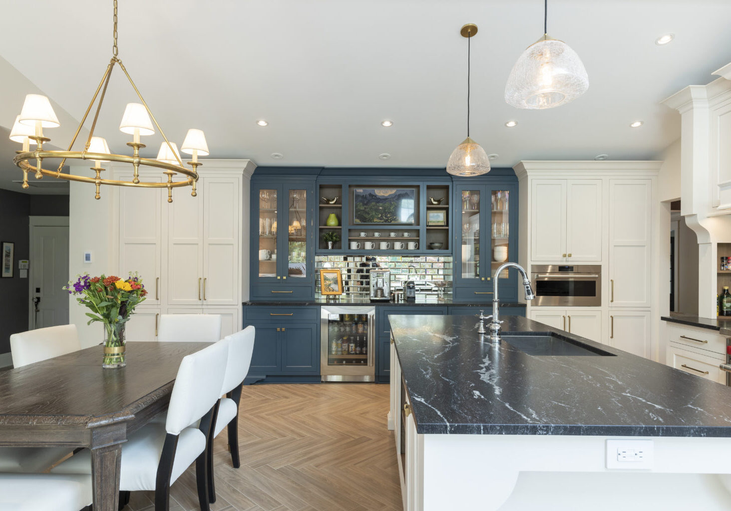 Residential kitchen showcasing dark countertops, and contrasting blue and white custom cabinetry, expertly designed and executed by R.E. McNamara Inc.